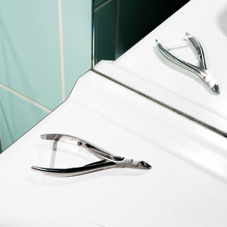 La pince à cuticules sur un lavabo de salle de bain.
