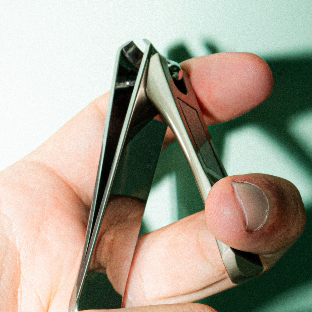 Une main qui tient le coupe-ongle pédicure premium de BA.