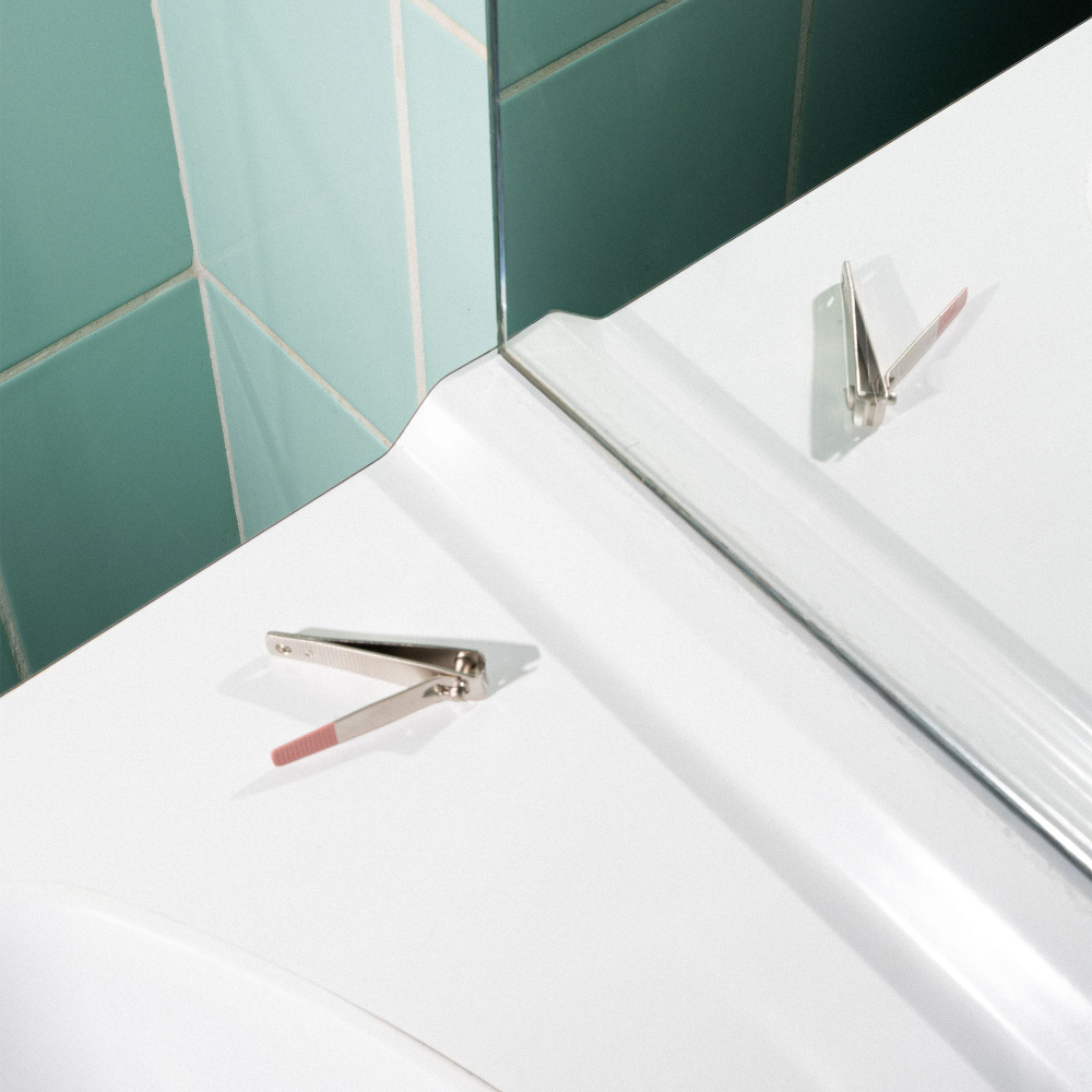 Le coupe ongle manucure de BA sur le rebord d'un lavabo.