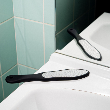 La rape pédicure au bord du lavabo dans la salle de bain.