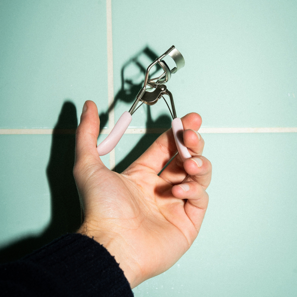 Un main qui tient un recourbe-cil